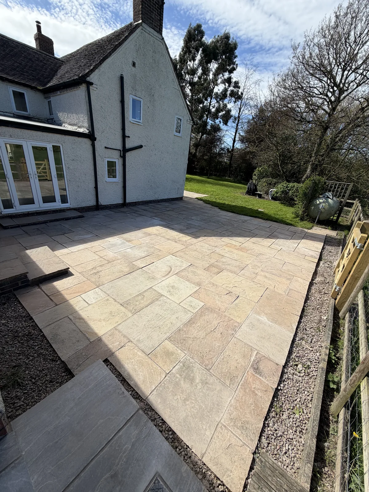A weathered sandstone patio restored to a brighter finish